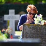 mourning/ woman mourning a deceased loved one on a graveyard