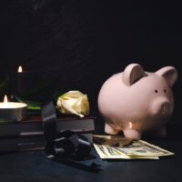 Composition with piggy bank and black ribbon on dark background