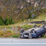 Car accident place on a bend, overturned car lies on the roof